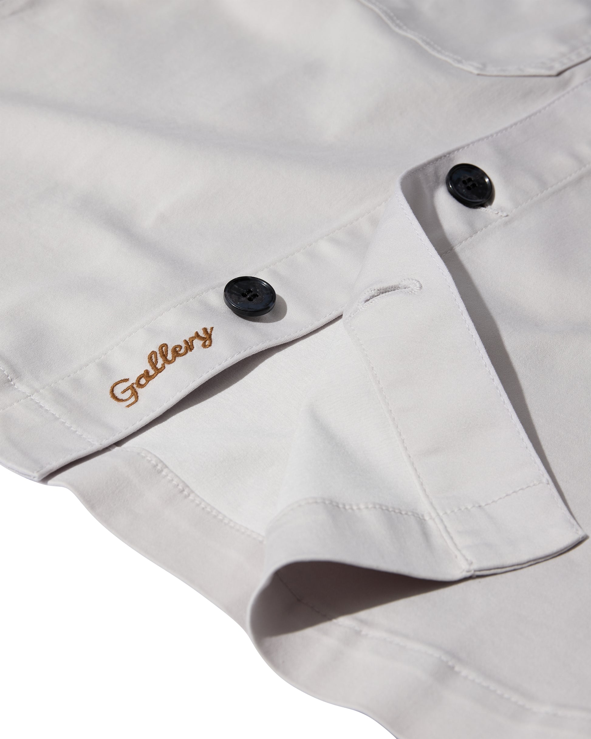 mens light grey cotton overshirt with black buttons and chest pockets close up