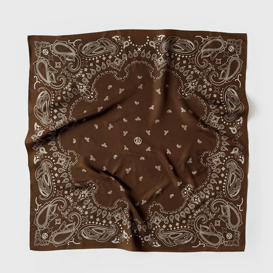 A square brown bandana featuring a classic paisley pattern in light beige, laid flat on a light gray background.