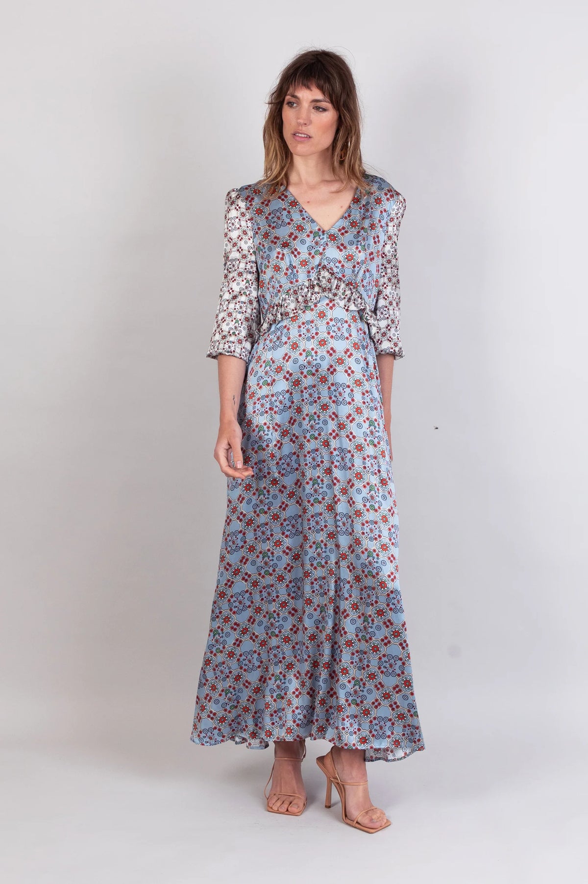 Oyster silk dress in a tile print with a long sleeve and ruffle detail
