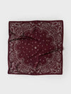 A square bandana in deep burgundy with a detailed paisley pattern in light gray, laid flat on a light gray background.