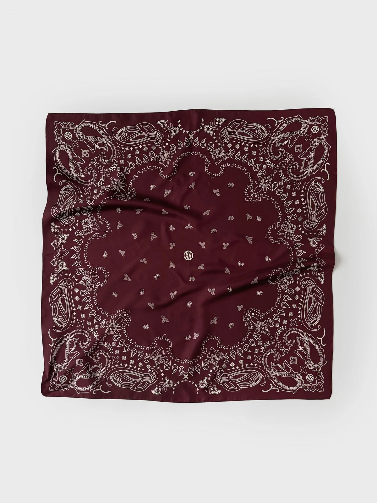 A square bandana in deep burgundy with a detailed paisley pattern in light gray, laid flat on a light gray background.
