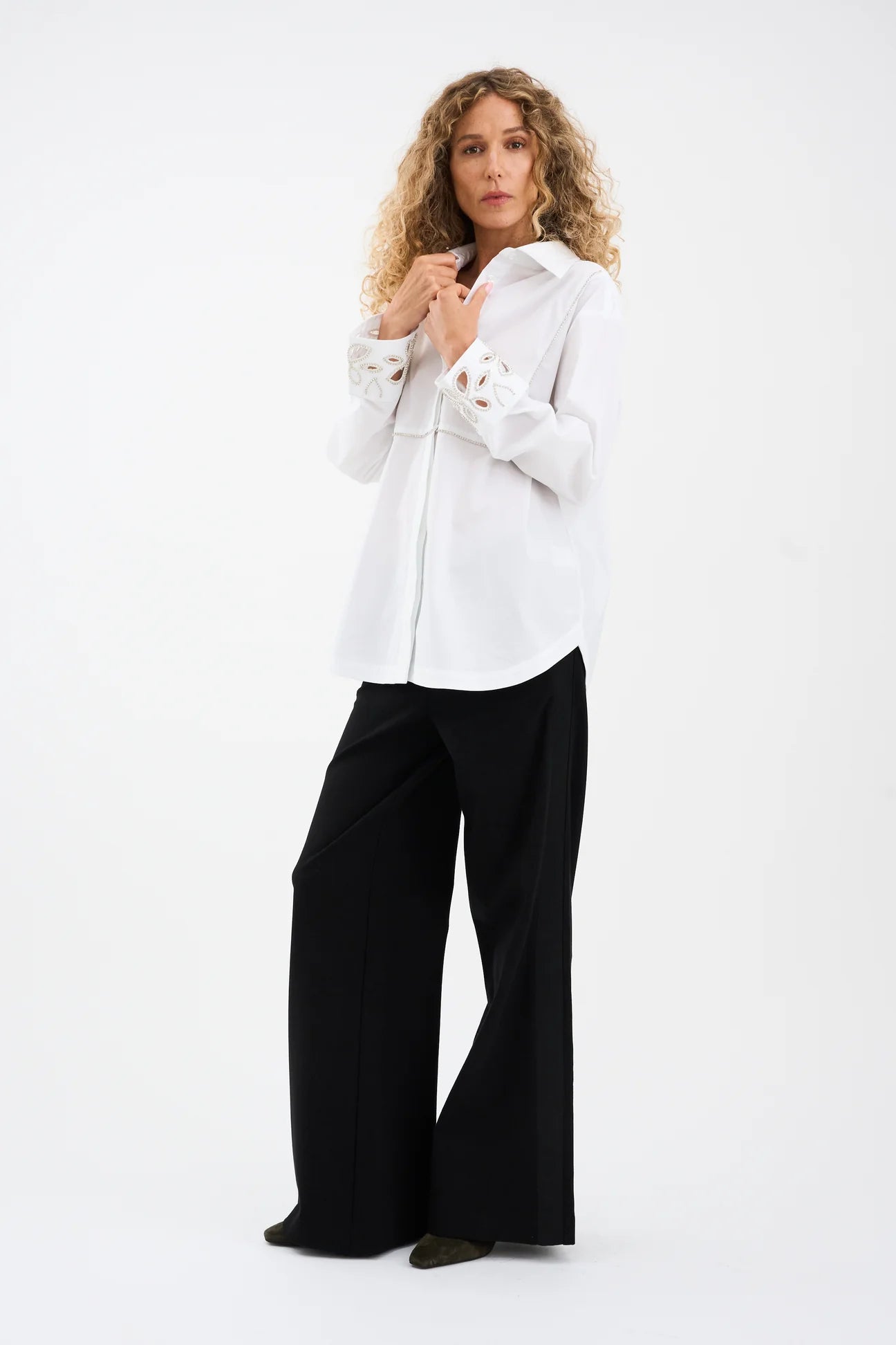 Woman wearing a white blouse and black pants on a white background from Pieszak