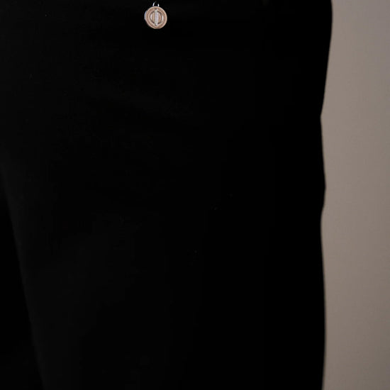 Black pants with a small decorative button on a neutral background from Pieszak