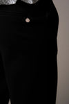 Black pants with a small decorative button on a neutral background from Pieszak