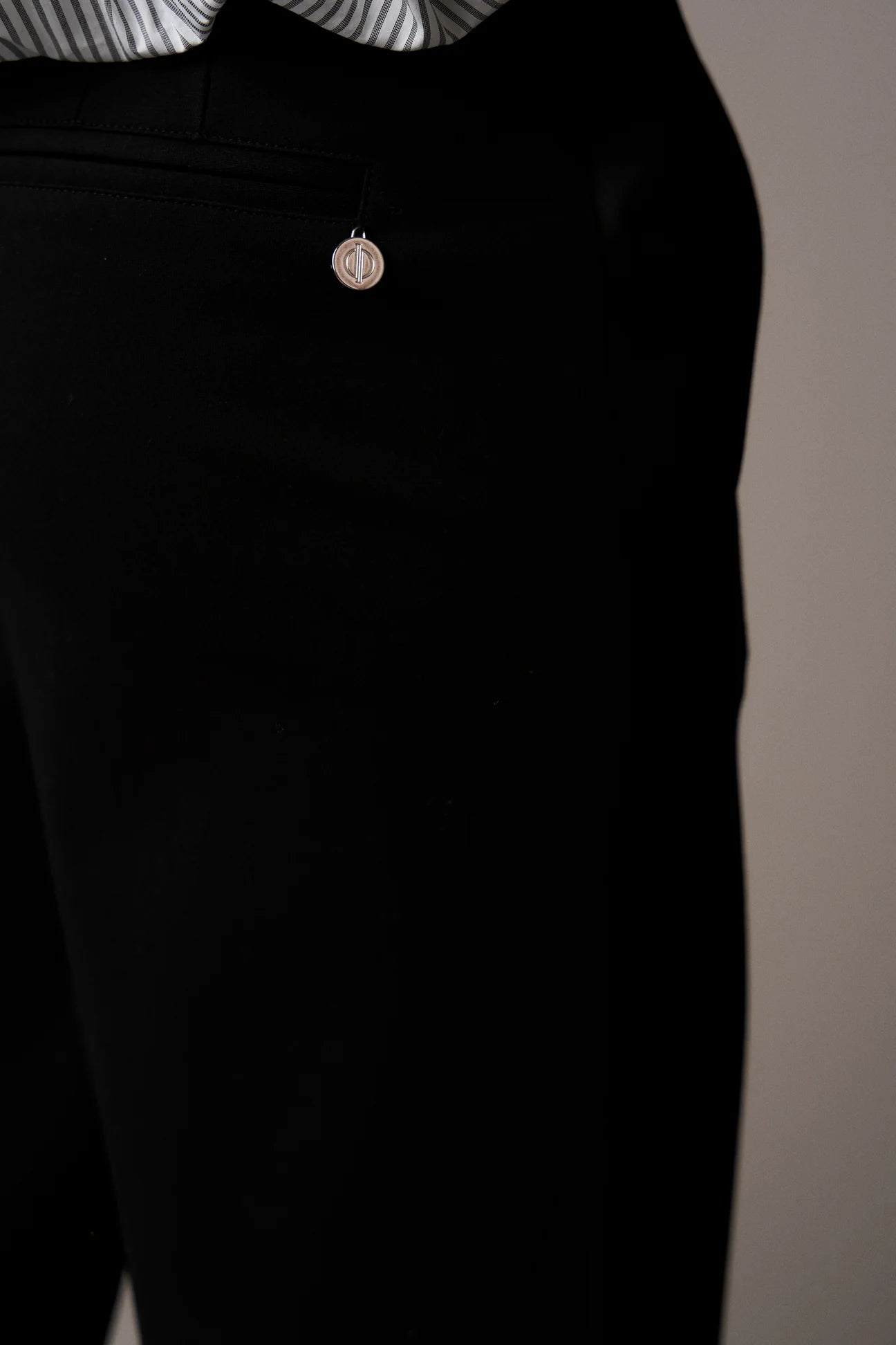 Black pants with a small decorative button on a neutral background from Pieszak