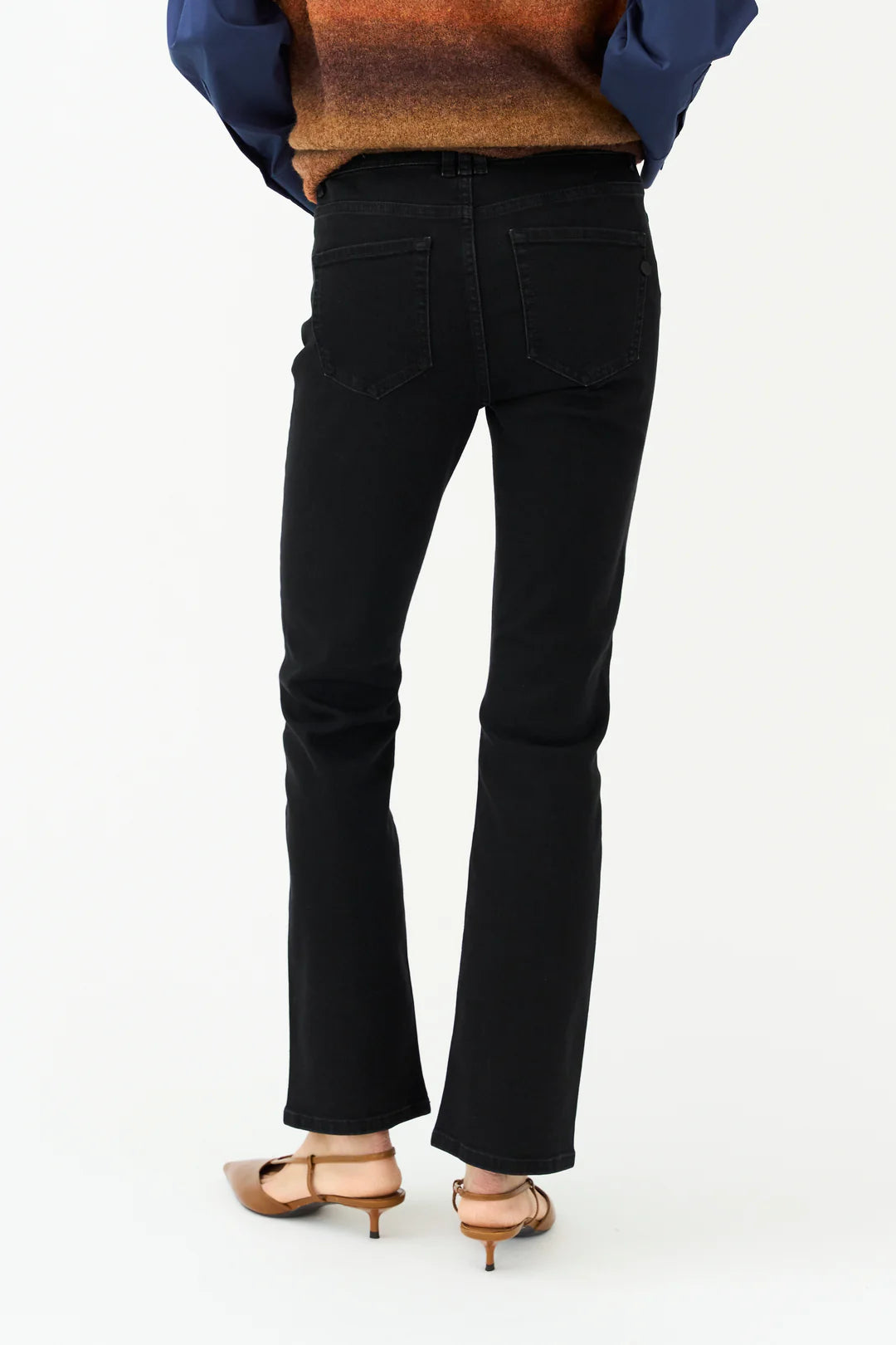 Black jeans worn by a person on a white background