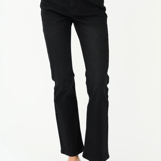 Person wearing black jeans on a white background