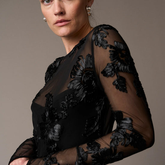 black mesh sheer blouse with fitted bodice and embroidered floral stitching from pieszak  model shot side view 