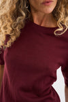 Close-up of a person wearing a burgundy sweater with a blurred background from Pieszak