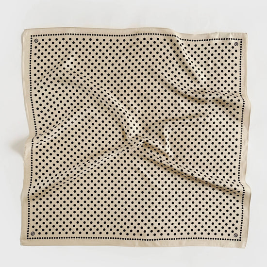 Beige silk scarf with black polka dot pattern on a white background