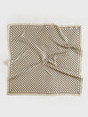 Beige silk scarf with black polka dot pattern on a white background