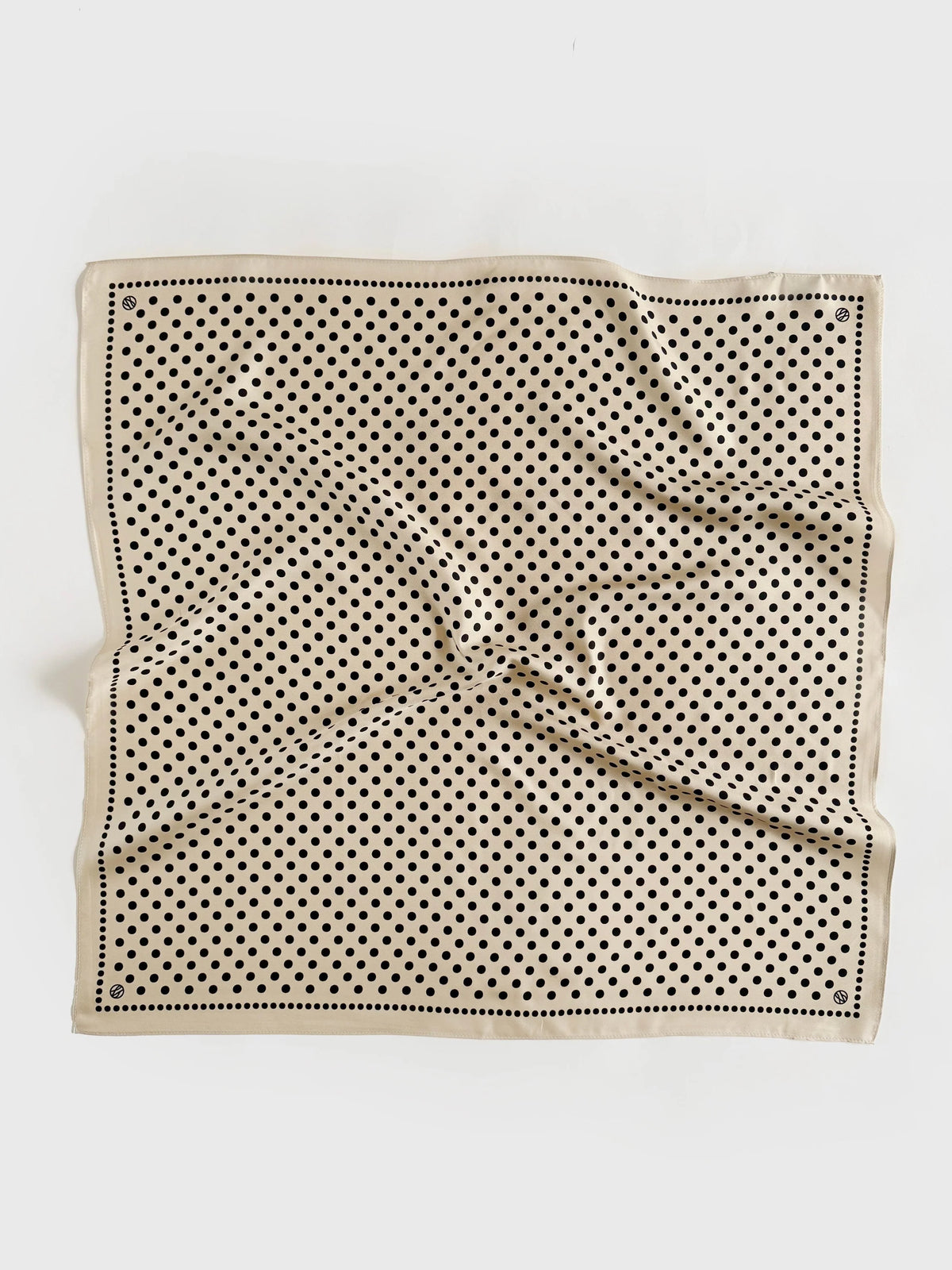 Beige silk scarf with black polka dot pattern on a white background