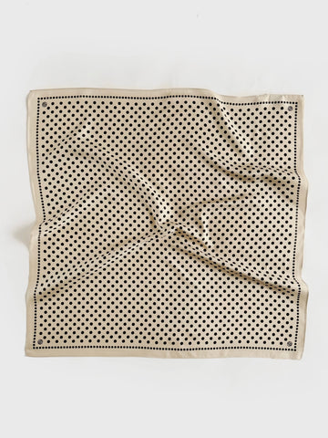 Beige silk scarf with black polka dot pattern on a white background
