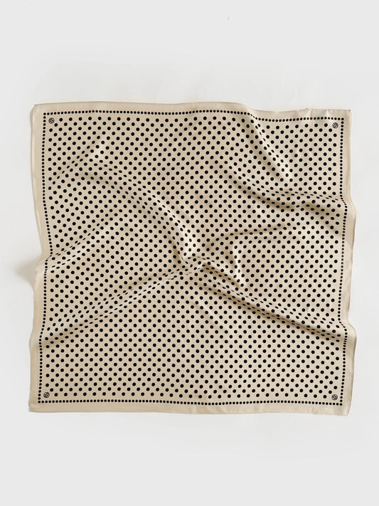 Beige silk scarf with black polka dot pattern on a white background