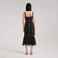 Fitted midi black cord dress with peplum hem and thick straps with bustier bodice and see-through lace lined from waist to knee