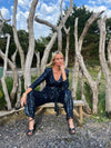 navy sequin jumpsuit with v neck, long sleeves and shoulder pads model shot