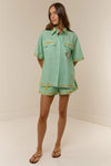 short sleeve light green oversized linen shirt with button flap pockets and crab on pockets from palm noosa model shot