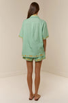 short sleeve light green oversized linen shirt with button flap pockets and crab on pockets from palm noosa rear
