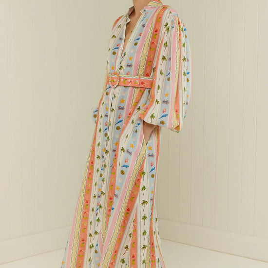 maxi length linen dress with tropical print, puffy long sleeves and belted waist side view