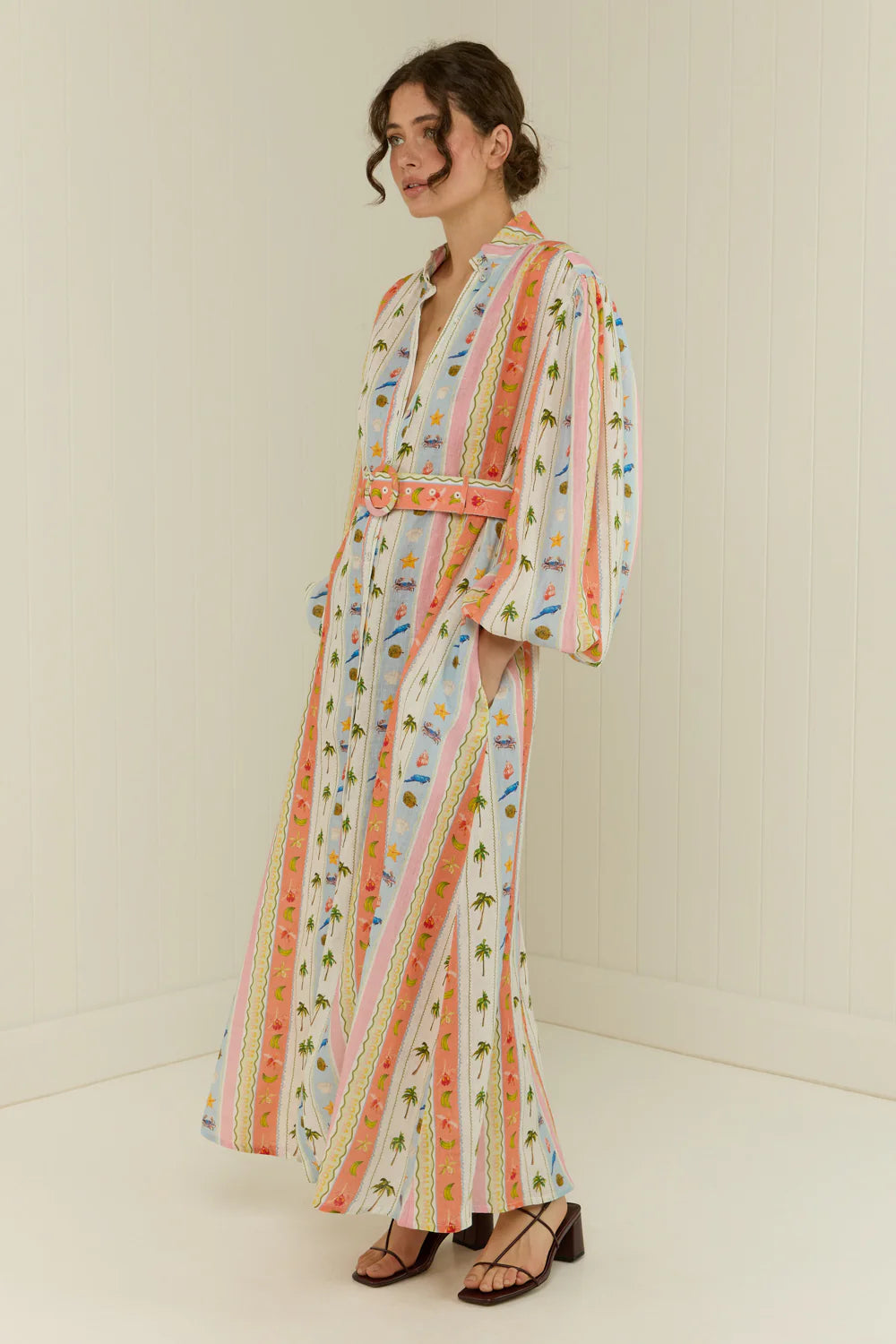 maxi length linen dress with tropical print, puffy long sleeves and belted waist side view