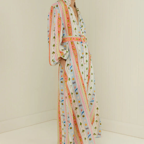 maxi length linen dress with tropical print, puffy long sleeves and belted waist side view 