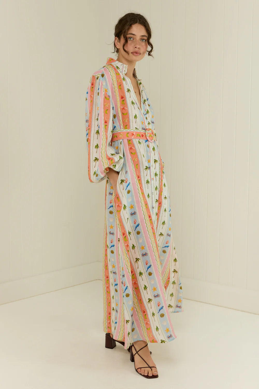 maxi length linen dress with tropical print, puffy long sleeves and belted waist side view 