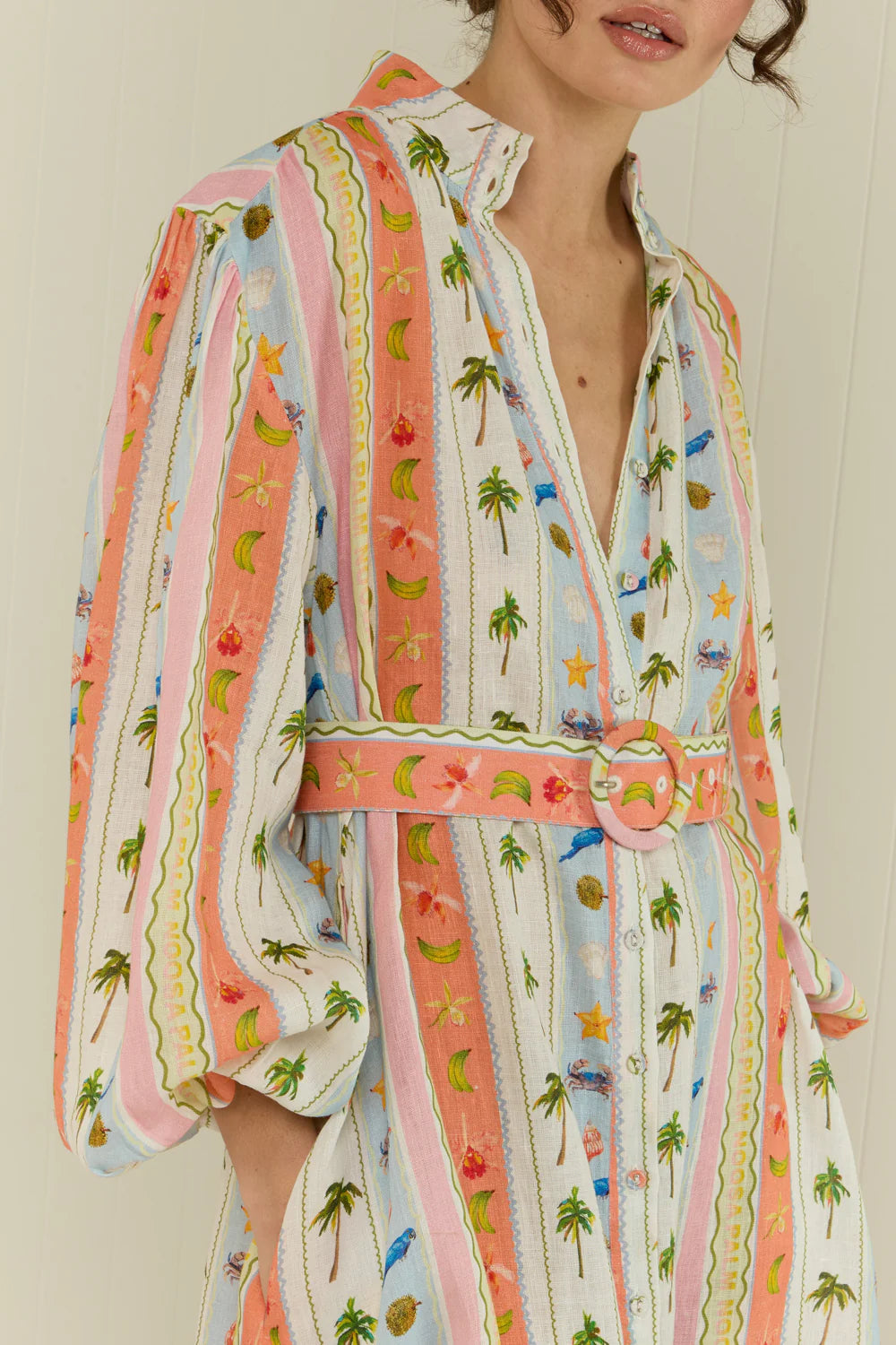 maxi length linen dress with tropical print, puffy long sleeves and belted waist close up