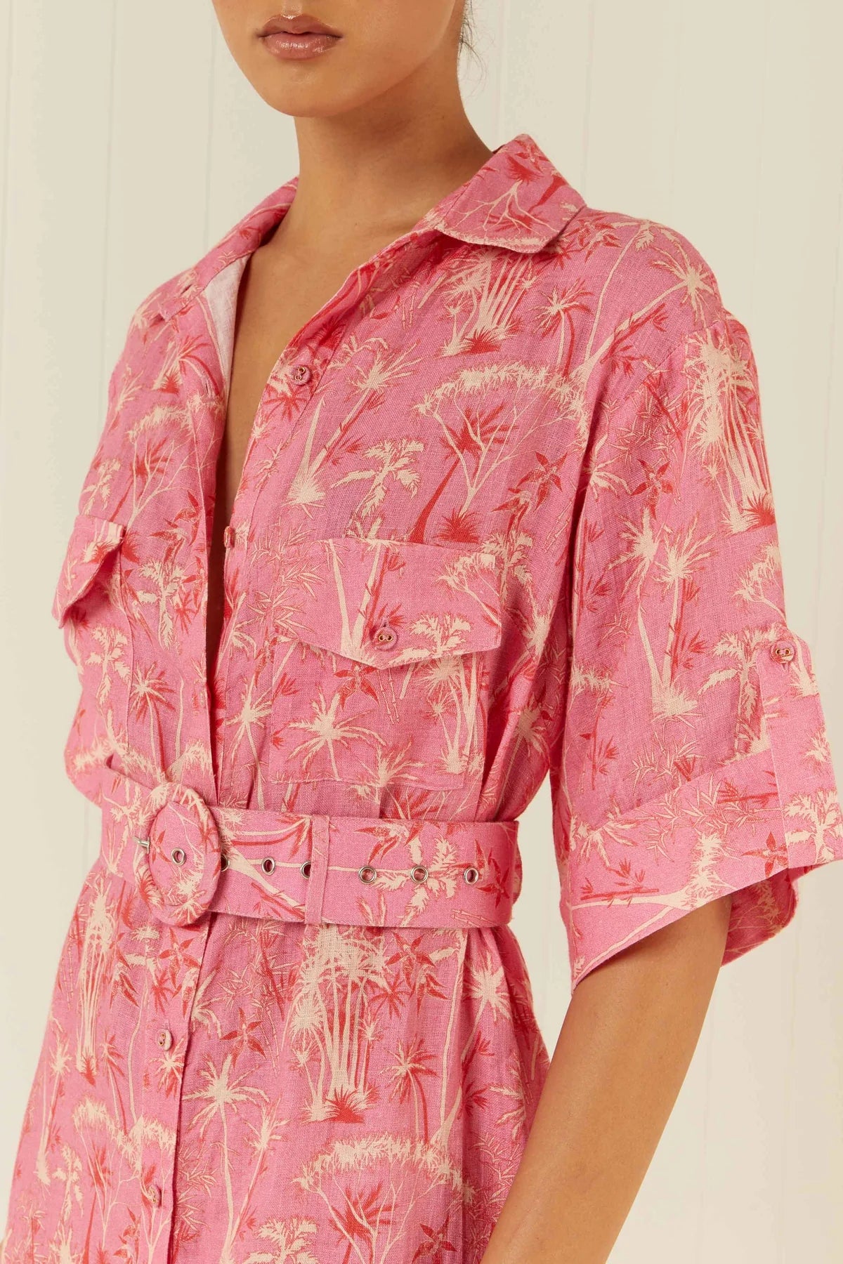 Palm tree print shirt dress in pinks and reds with short sleeves close up
