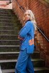 blue roll neck with ribbed cuffs, hem and neck with colourful floral design side view 