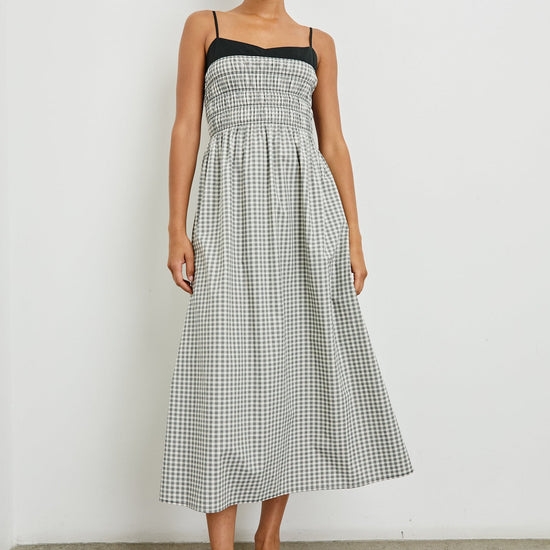 Woman wearing a black and white checkered dress against a plain background