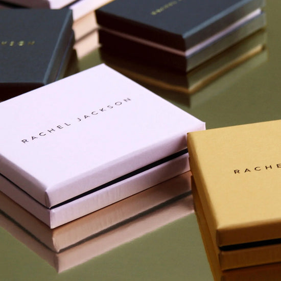 Stacks of Rachel Jackson boxes on a reflective surface