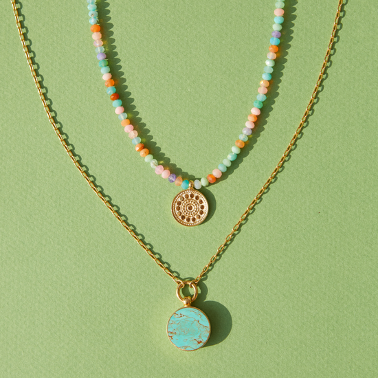 Two Anna Beck Necklaces on a green background