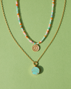 Two Anna Beck Necklaces on a green background