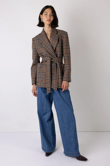 brown check blazer with tie belt worn with  blue denim