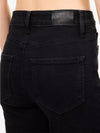 Close-up back view of a person wearing black denim jeans, showing the waistband, belt loops, and back pocket details.