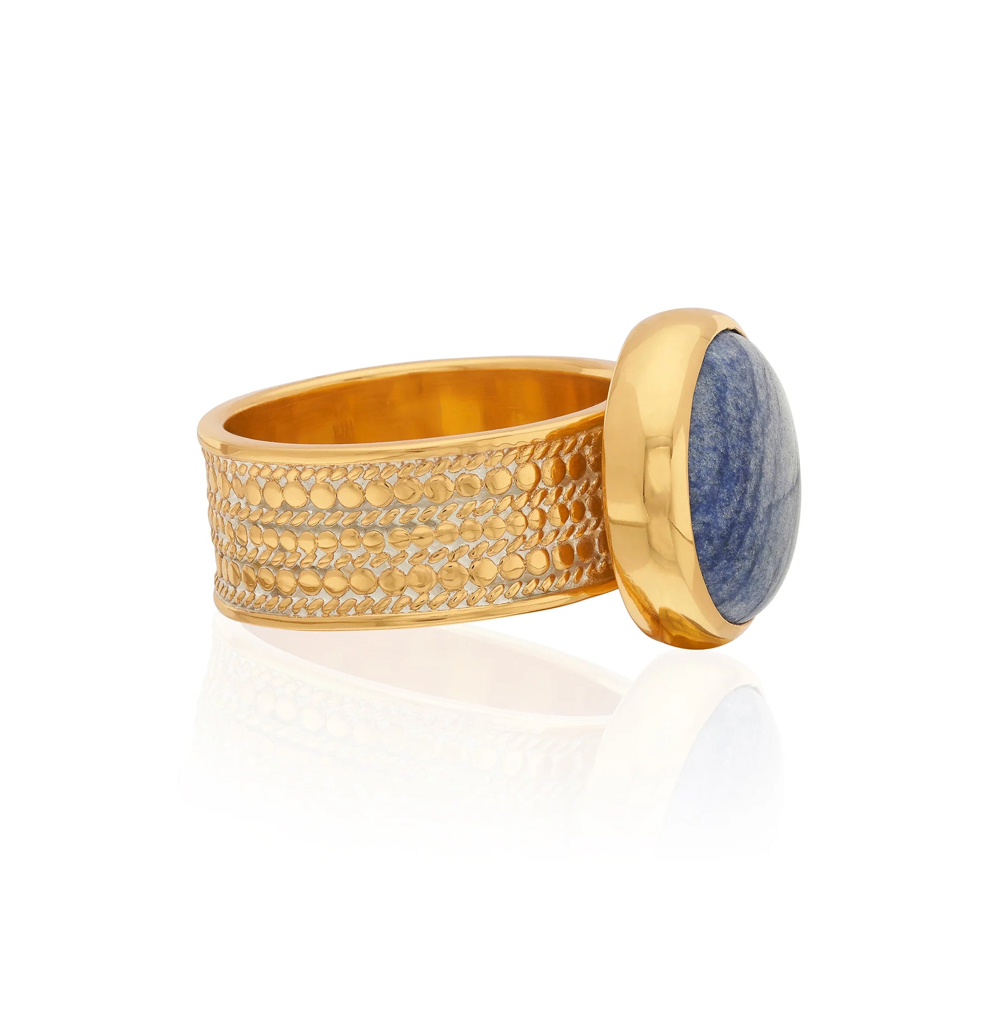 Side view of gold cocktail ring with a blue stone