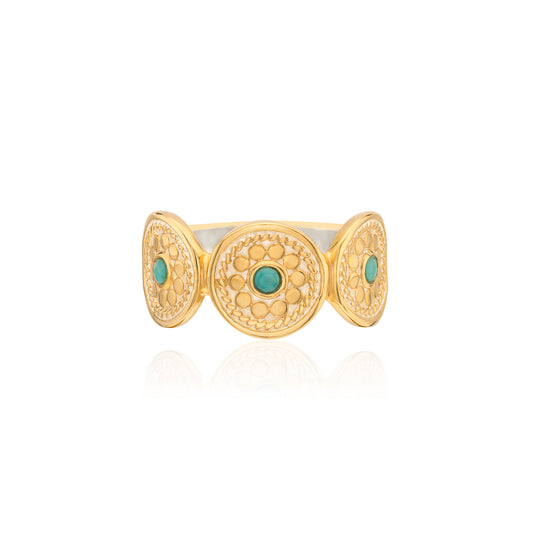 Gold ring with turquoise stones on a white background