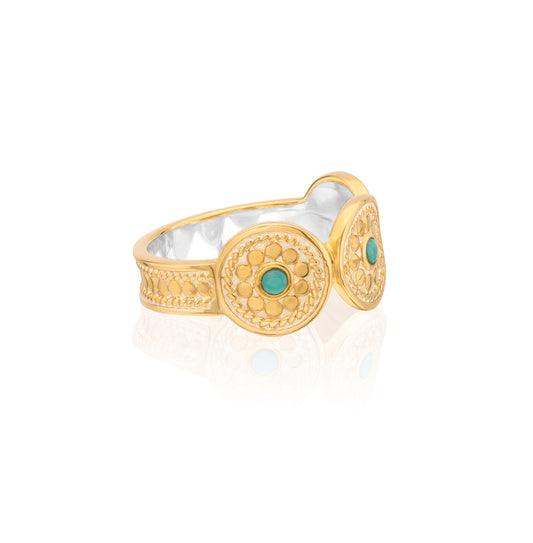 Gold and silver ring with turquoise stone on a white background