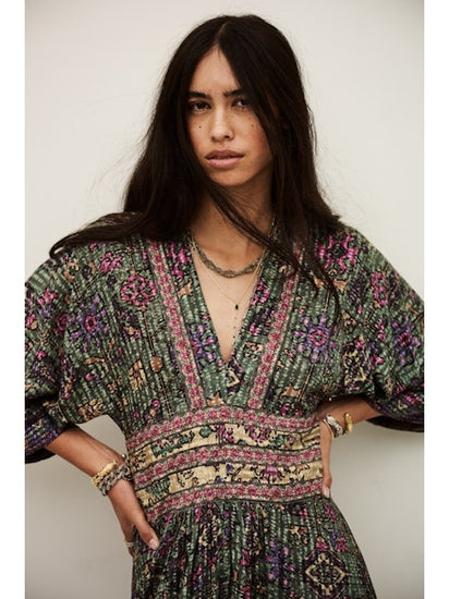 Woman wearing a patterned dress against a plain background