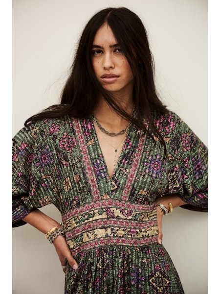 Woman wearing a patterned dress against a plain background