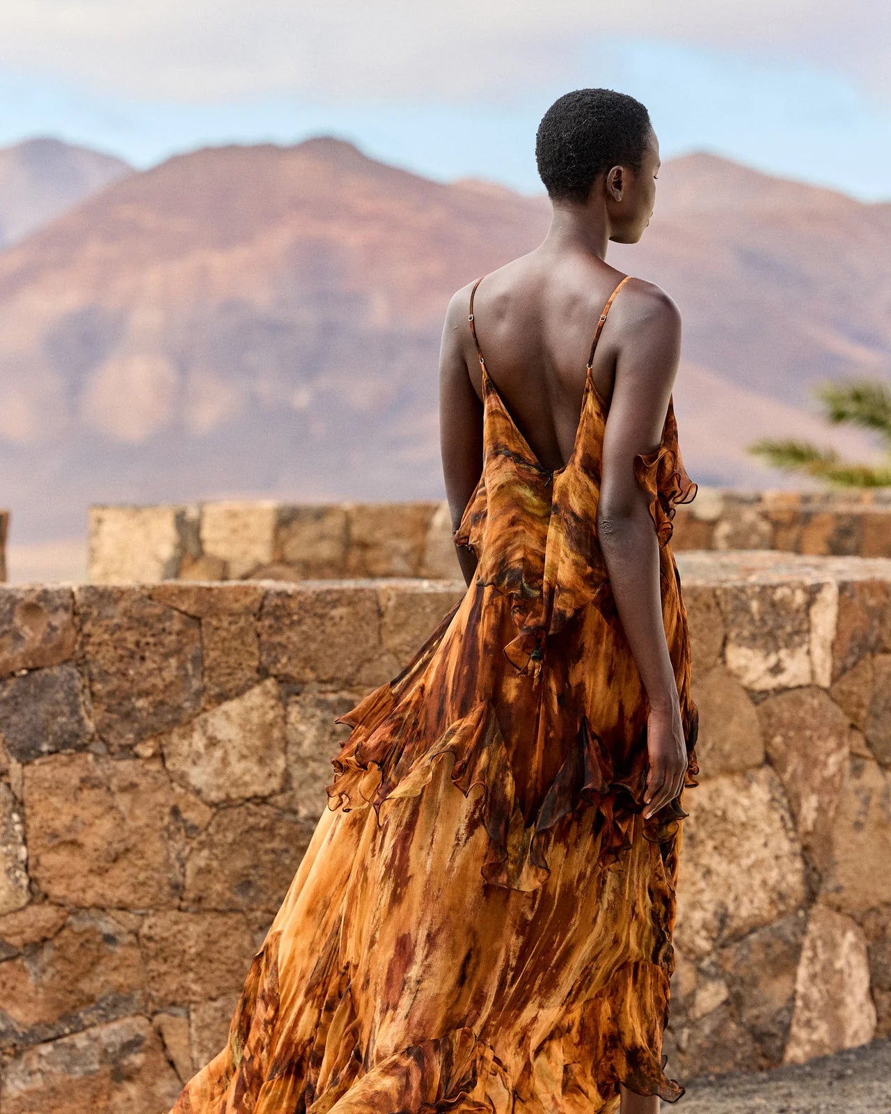 Rear view of tiered tie die dress with spaghetti straps