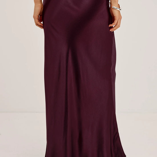 Woman wearing burgundy skirt and jumper rear view