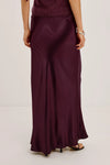 Woman wearing burgundy skirt and jumper rear view