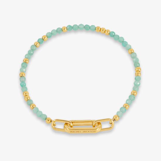 Bracelet with green beads and gold clasp on a white background