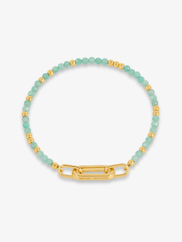 Bracelet with green beads and gold clasp on a white background