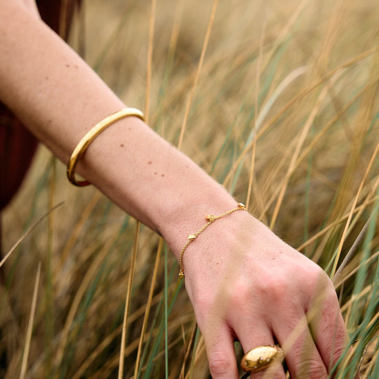 Rachel Jackson gold bird bracelet on a wrist