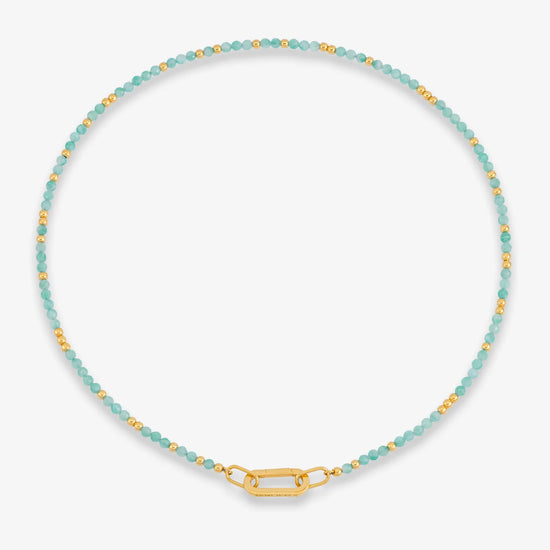 Necklace with blue beads and gold clasp on a white background