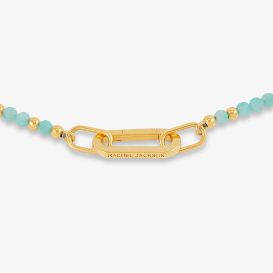 Gold bracelet with turquoise beads on a white background