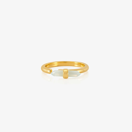 Gold ring with a white stone on a white background