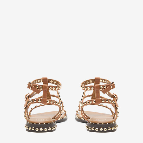 Pair of gold sandals with studded details on a white background rear view